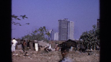 1970: what appears to be a shanty town in india set against a modern city