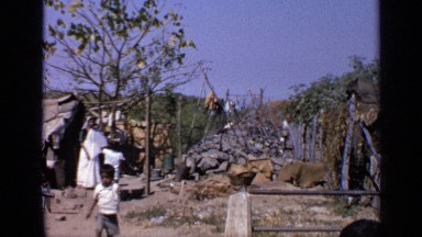 1970: people and children moving about in what appears to be a shanty town