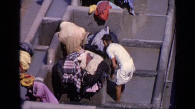 1970: Men and Women Wash and Sort Clothes at Outdoor Laundry in India