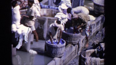 1970: Native Men Wash Clothes by Hand in Large Wooden Buckets in India