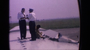 1970: an aircraft pilot standing on the wing and having a discussion with a crew