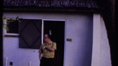 1969: a man is standing in front of the house, wearing watch and specs KENYA