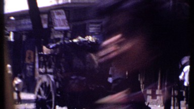 1969: an old street in the town with many people walking, standing