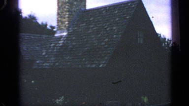 1969: footage showing the slate roof of a stone cottage on a fine day.