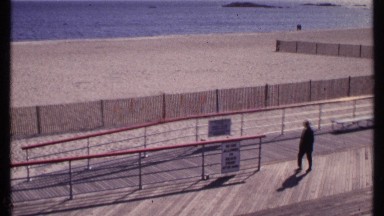 1969: people walk slowly along a boardwalk on the beach. NEW LONDON CONNECTICUT