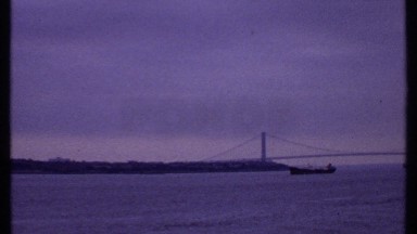 1969: a long bridge sitting over a large body of water with people and boats