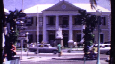 1969: a busy street of the city with many buildings, vehicles, people etc.