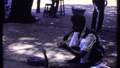 1969: a man using his instruments in front of snake and people watching it.