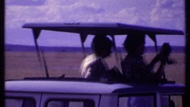 1969: men in a van taking photos of the african savannah. KENYA