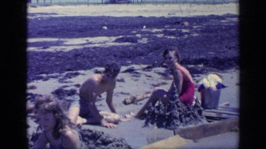 1968: Party of Teens Play in the Sand on a Beach