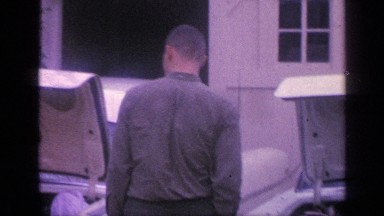 1968: man closes trunks of two cars parked side by side and then waves FLORIDA
