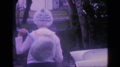 1968: girl in frilly hat swings back and walks around car. FLORIDA