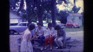 1968: party of friends gathered in table,enjoying eat with her mom FLORIDA