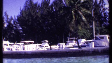 1969: in a beach full of ships and boats, trees around there. a beautiful place