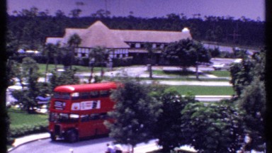 1969: bus arriving at the amusement park and people are gathered having fun.