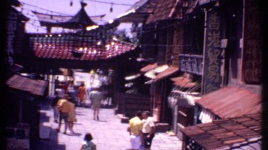 1969: tourists mill around an asian street in the sunshine. BAHAMAS
