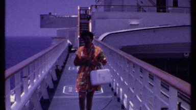 1969: woman in a red summer dress coming off a boat BAHAMAS