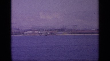 1963: Panoramic View of Harbour Town with Mountains in the Background. GREECE