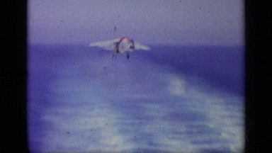 1963: a fighter jet smoothly landing on an aircraft carrier in the open sea