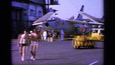 1963: People Walk Between Fighter Aircraft on a Navy Ship