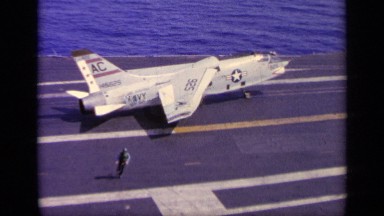 1963: man runs away as military airplane begins taking off from aircraft carrier