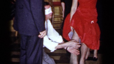 1966: Blindfolded Man Kneels and Feels Woman's Legs at Party