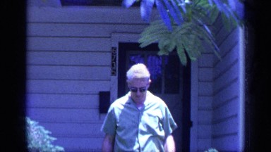1968: man walks toward camera taking off glasses and smiling. FLORIDA