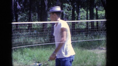 1968: Boy in a Hat Playing Badminton Outside Near a Net Florida