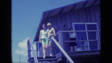 1968: a couple and their friend coming down from the steps to meet some people
