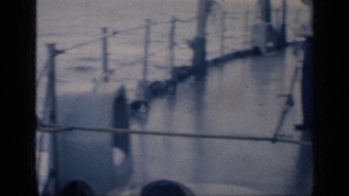1962: ship workers standing on the ship balcony while the ship sailing
