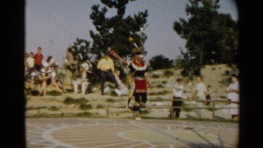 1959: two native-american men walk out into an arena in traditional ceremonial
