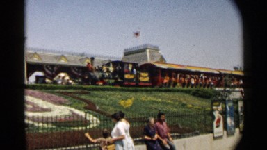 1959: a train is moving fast at the track and kids with family watching
