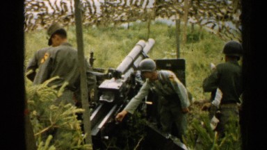 1952: army personnel wearing helmets fire a large cannon in a field. JAPAN