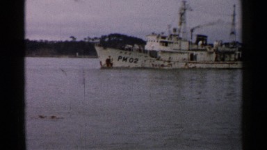 1952: a medium size ship is moving on the water at the evening time with people.