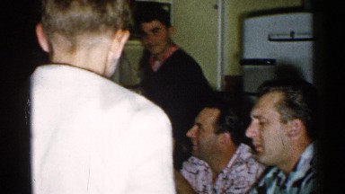 1952: people gathered in a house enjoying themselves while smoking a cigarette.