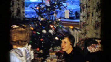 1952: a group of people celebrating christmas night,smiling and talking