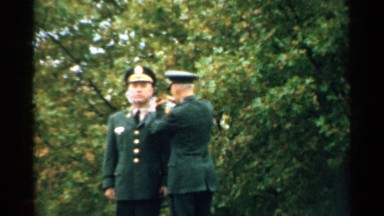 1952: an office fixing the badges on the shoulder of another one during a