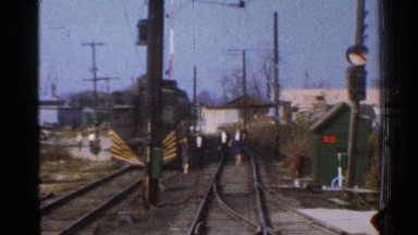 1953: some people are crossing on the railway platform and a luggage train