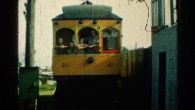 1953: passengers look out of the back of a trolley as it leaves the station.