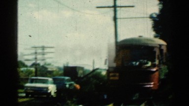1953: a single red engine train or trolley car approaching on the tracks