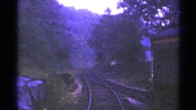 1953: view from the front of a train as it winds through a wooded area.