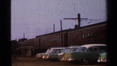 1953: seven different cars parked next to a train at a train yard CONNECTICUT