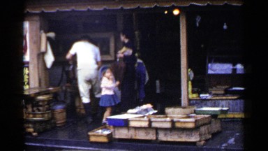 1953: People Standing Near Shop in Japan