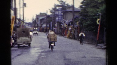 1953: bicyclists moving through a narrow street in a village town JAPAN
