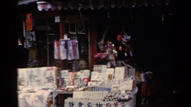 1953: busy street with market stalls selling their wares to passers by. JAPAN
