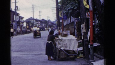 1953: the men cycling ther cart on the middle of road with load JAPAN