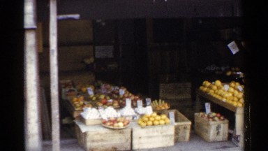 1953: a small produce grocery displays bins and boxes of fresh fruit