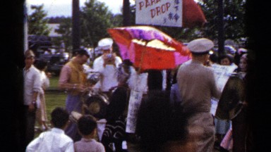 1953: a bunch of people gathered around entertainers and having fun JAPAN