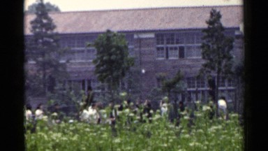 1953: people are playing at the garden in front of the building at the morning