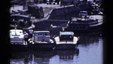 1953: boats at a dock with people standing on the dock JAPAN